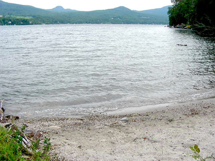 Lake access includes a sandy beach along this pristine lake.