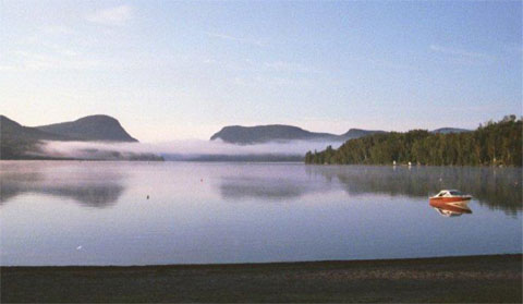 This is a famous view of the twin mountains and lake from the North Beach that includes a public sandy beach